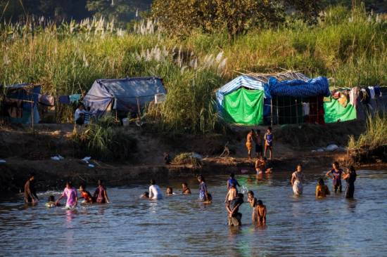 Fleeing violence in Myanmar, thousands camp along Thai border river