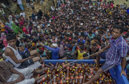 Rohingya refugees wait during distribution of food items in 2017 in Bangladesh